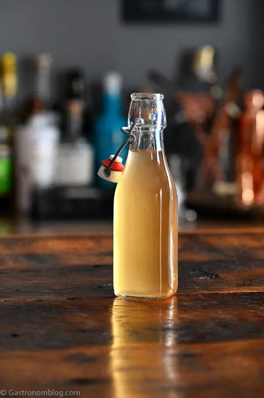 Bottle with light tan peach liqueur on a wooden table