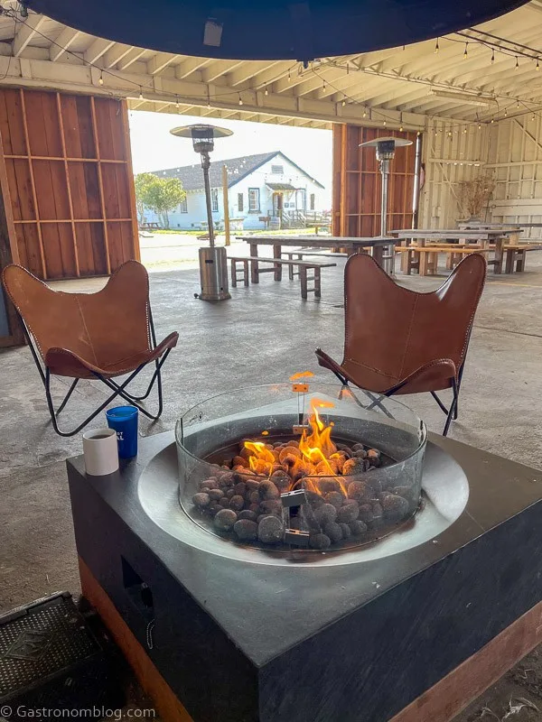 Inside of Humboldt Bay Social Club Hanger with fire pit and leather butterfly chairs