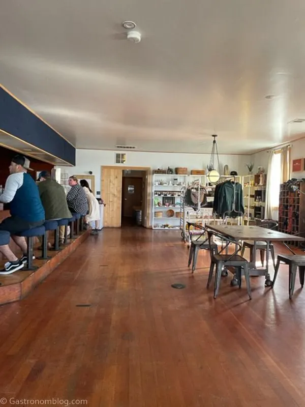Inside of Humboldt Bay Social Club, people at the bar, and corner has souveniers