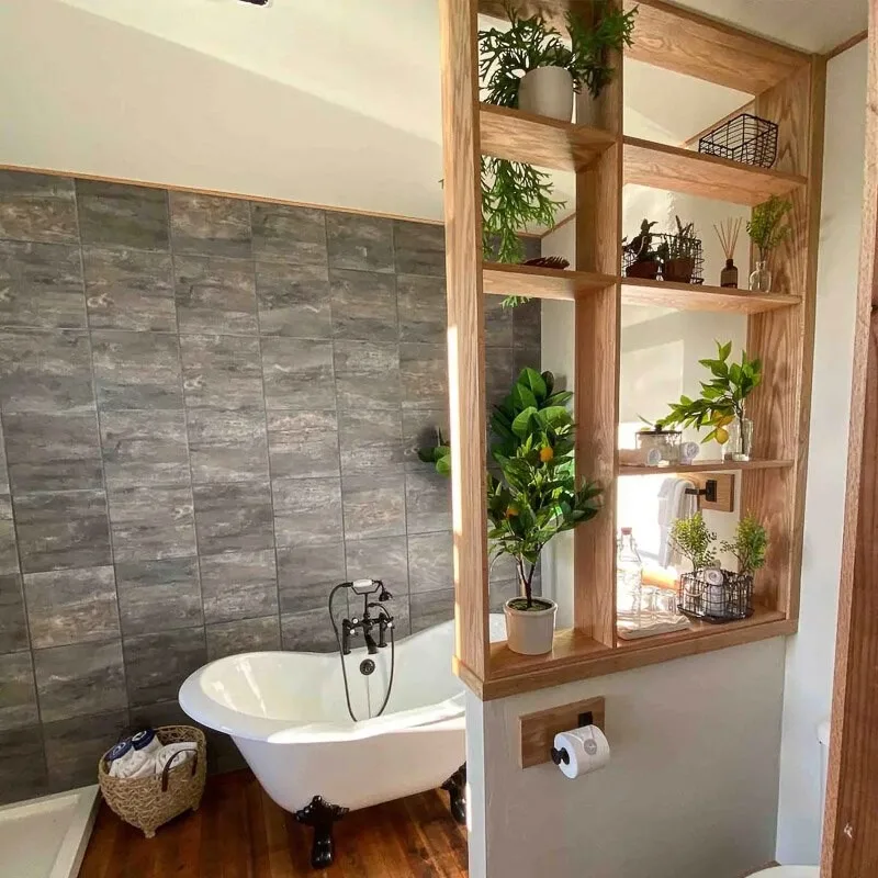 Clawfoot tub in bathroom at Humboldt Bay Social Club, plants on wooden grid shelf