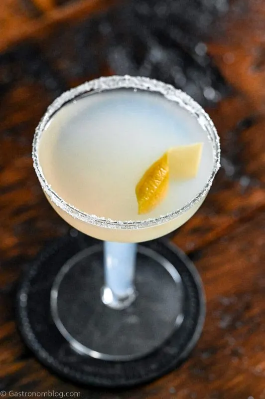 Opaque cocktail in coupe with sugar rim on wooden surface