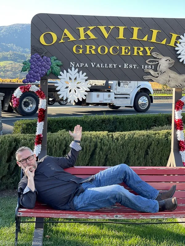 Man lying on bench at Oakville Grocery Napa Valley