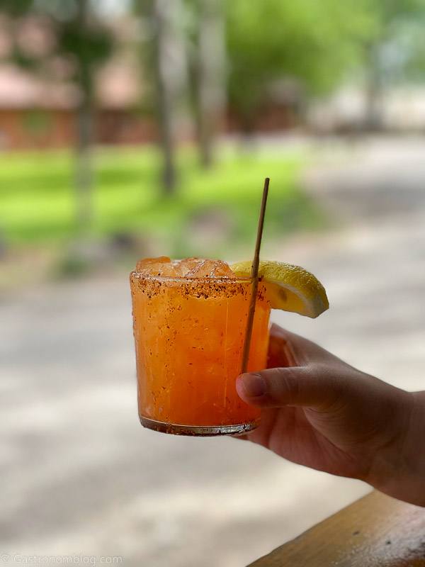 orange cocktail held by hand at Hell's Backbone Grill