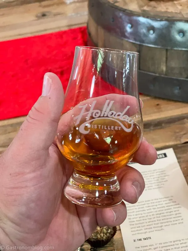 hand holding whiskey in a tasting glass