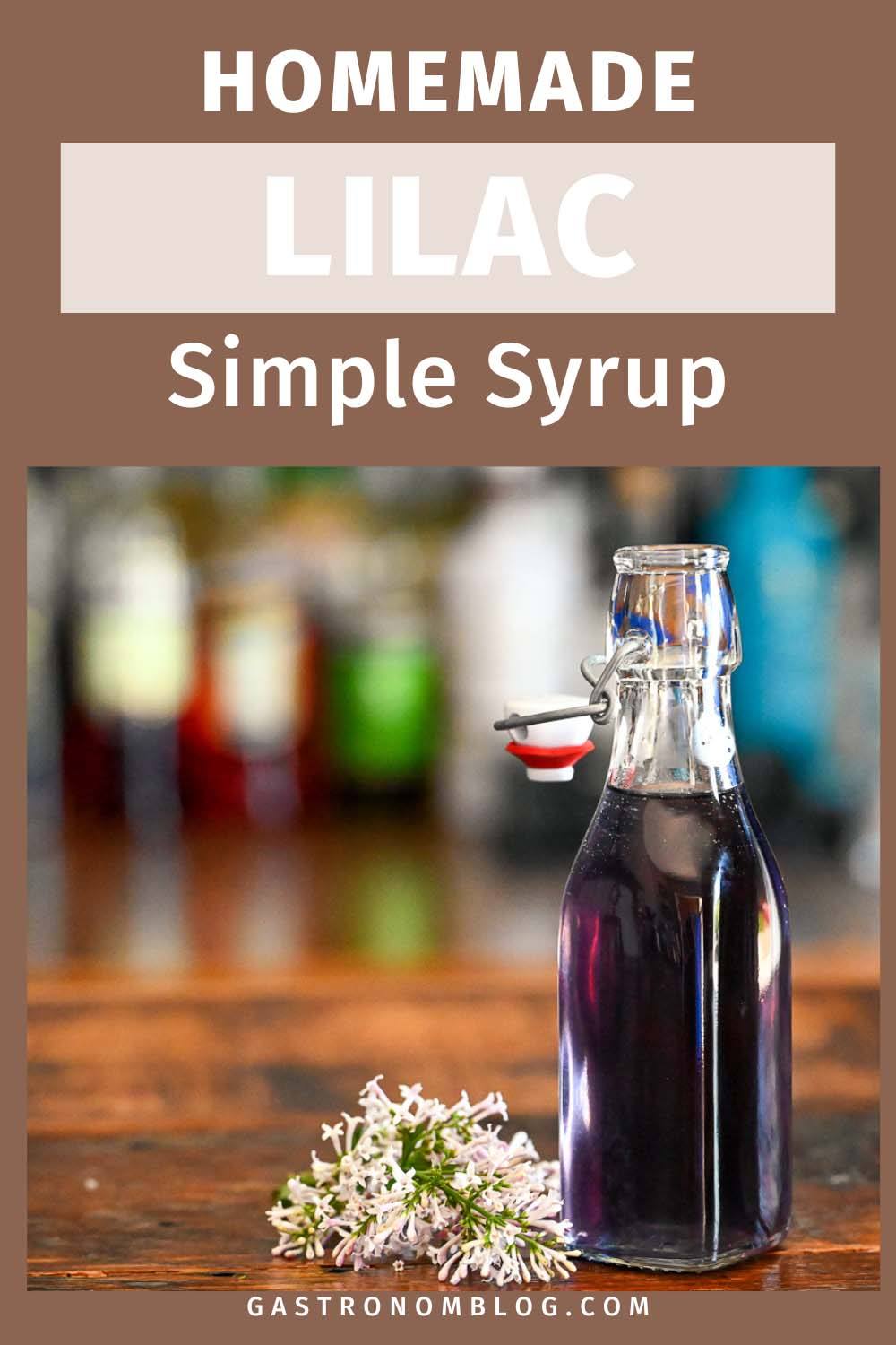 purple lilac simple syrup in a bottle, lilacs next to bottle on wood table
