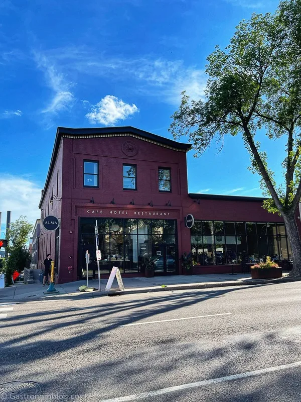 Red building with 2 stories on left side and 1 on right - Hotel Alma Minneapolis