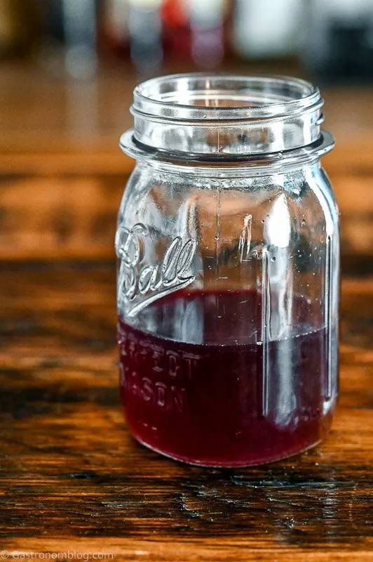 Purple Blackberry syrup recipe in glass jar on wooden table