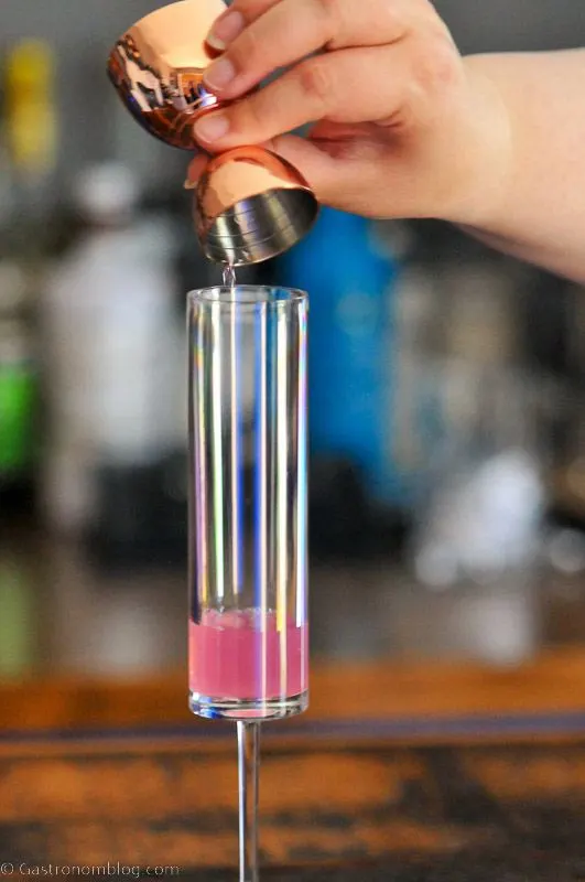pink syrup being poured into tall glass