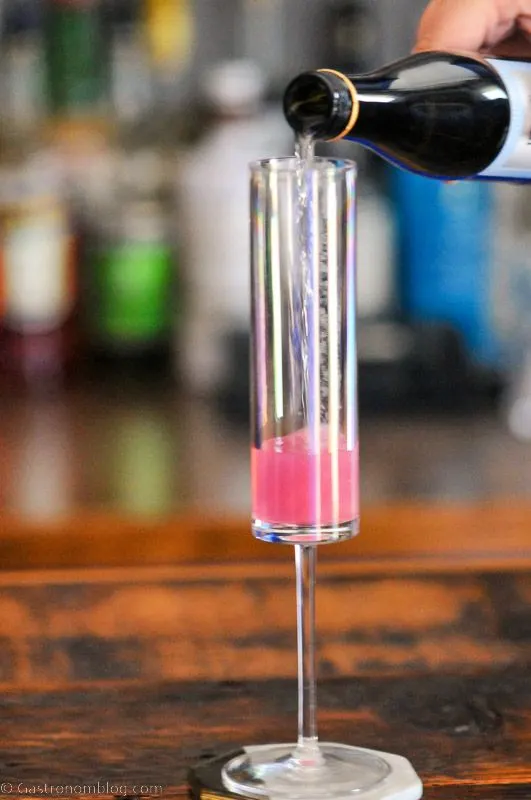 champagne being poured into glass with pink liquid