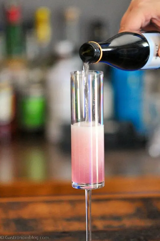 champagne being poured into glass with pink liquid