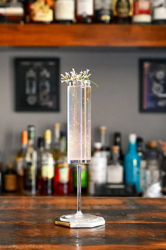 Hazy pink cocktail in tall glass on wood table