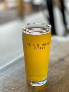 Golden cider in glass on table at Milk and Honey Ciders