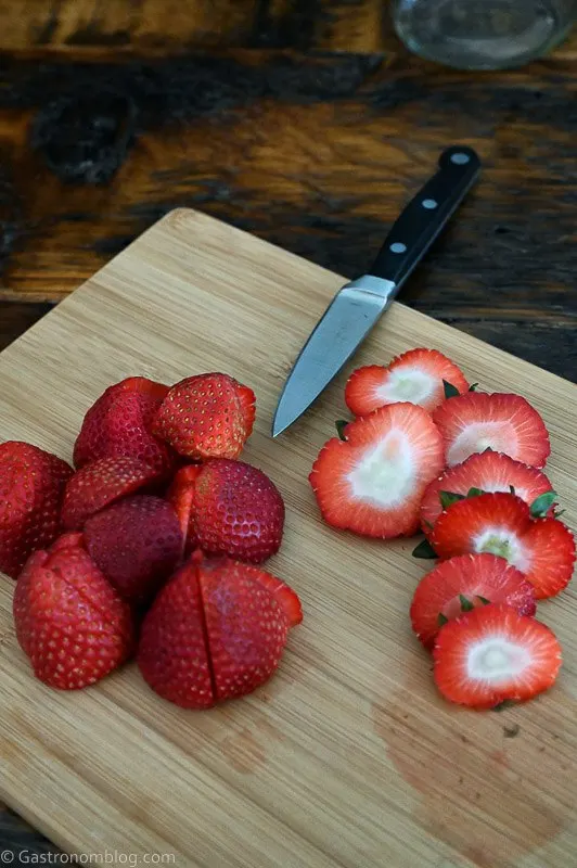Cut strawberries on a cutting board with knife