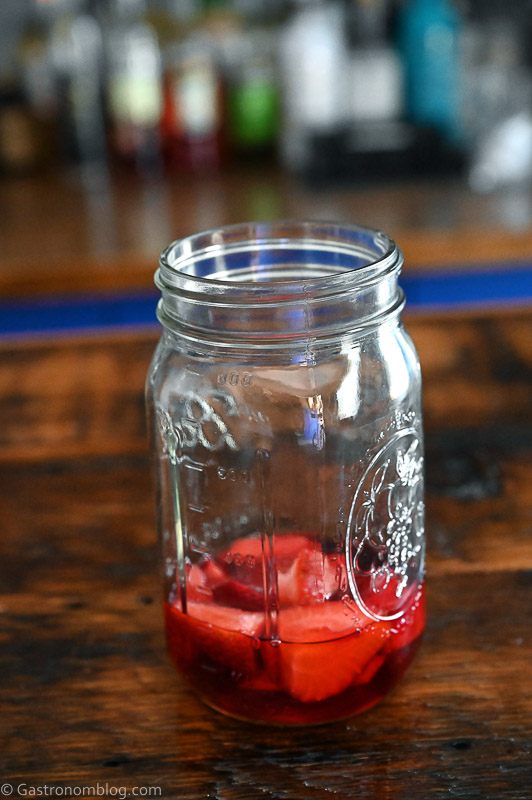 Cut strawberries covered with Campari in jar