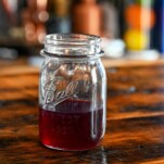 Рецепт сиропа из фиолетовой ежевики в стеклянной банке на деревянном столе
