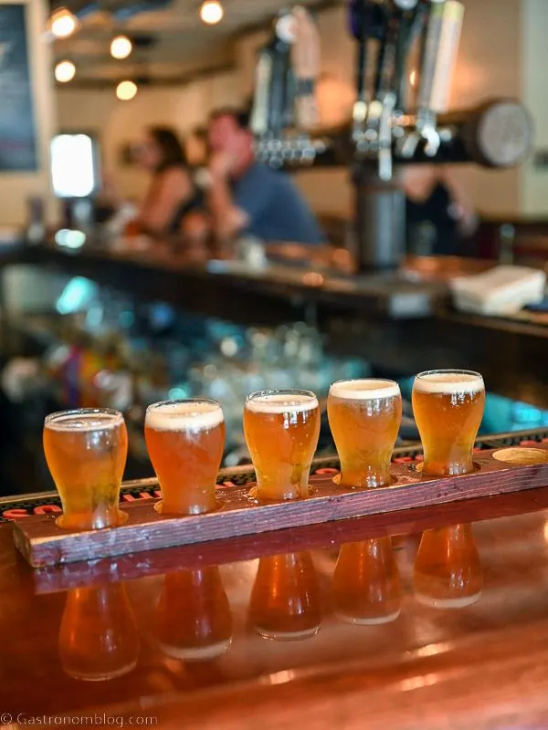 Lineup of beers in small glasses as tasting on a board
