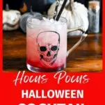 red drink in skull mug, Halloween straws and decor in background