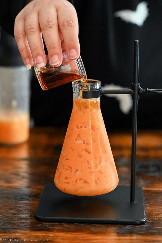 Orange Pumpkin cocktail being poured into a beaker