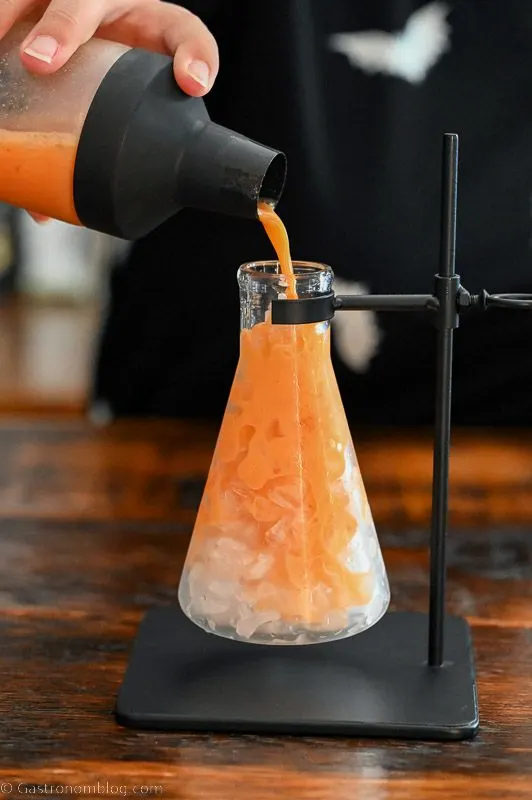 Orange Pumpkin cocktail being poured into a beaker