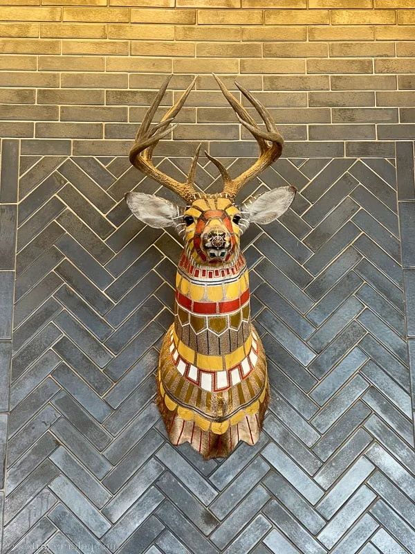 Wooden deer head on gray tiled wall at Hewing Hotel Minneapolis