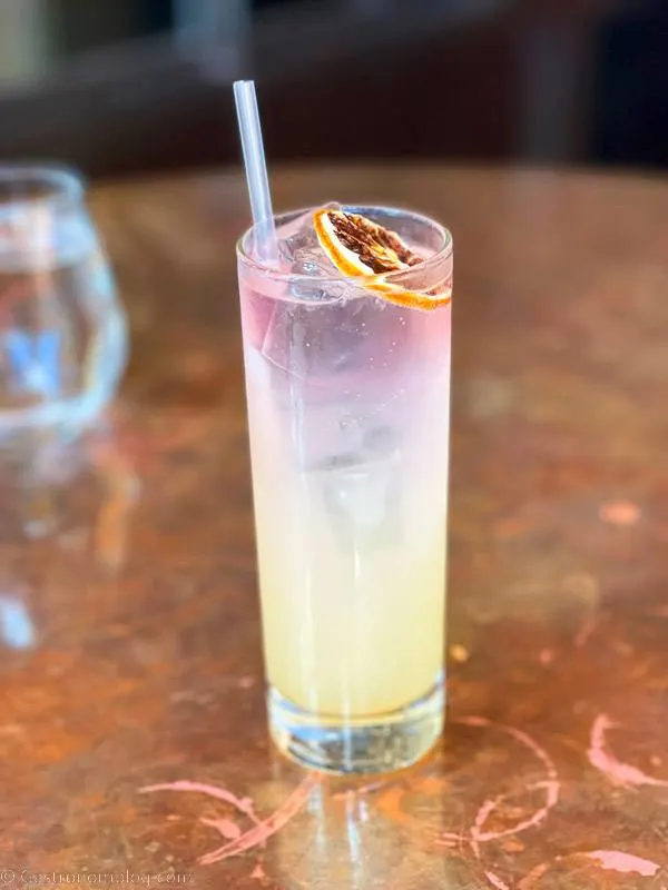 Yellow and purple cocktail in tall glass
