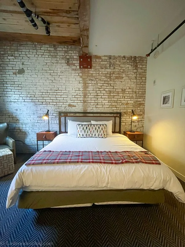 Hotel room, bed on brick wall at Hewing Hotel Minneapolis, Minnesota