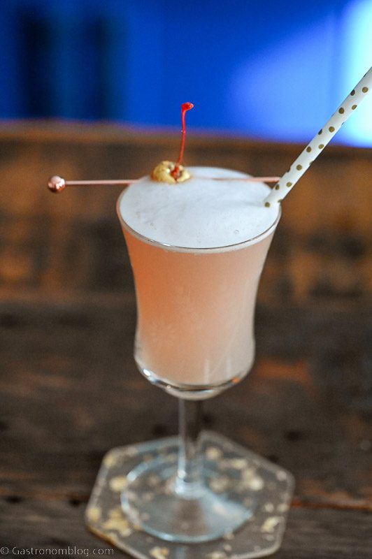 Pink Blood Orange Gin cocktail in tall glass with straw and cherry