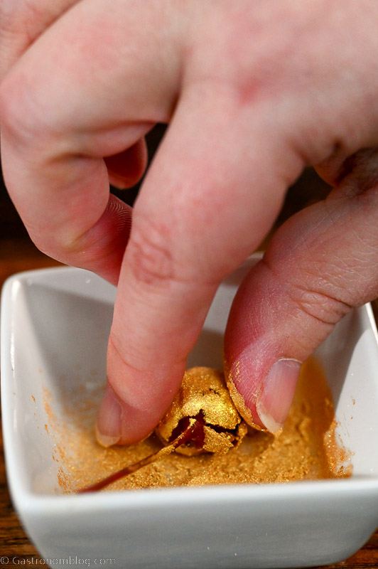Hand holding a gold glitter cherry