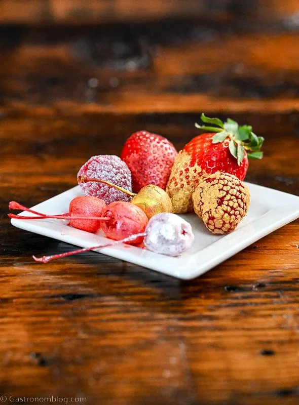 white plate of glittered fruit garnishes