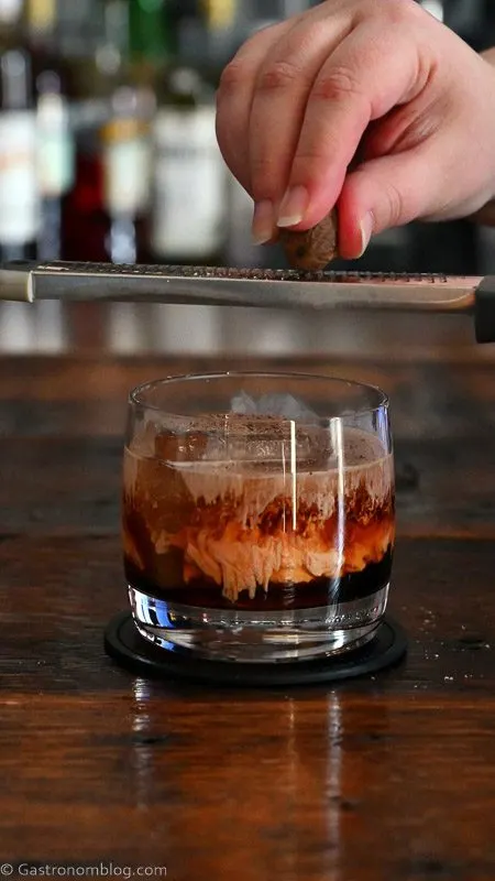 Orange and brown carrot cake cocktail in rocks glass with separate layers