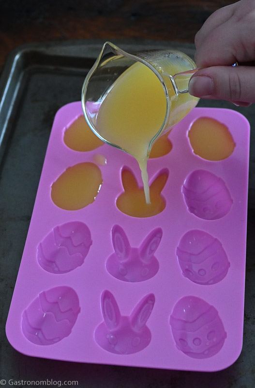 orange juice being poured into pink ice mold