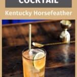 tan Kentucky Horsefeather Cocktail in tall glass with rose etched, lime slice and straw