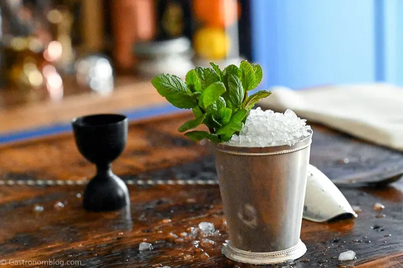 Mint Julep in a silver cup with crushed ice and mint leaves on wooden table