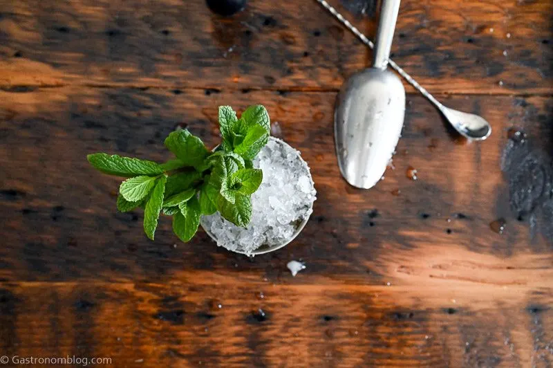 Mint Julep in a silver cup with crushed ice and mint leaves on wooden table