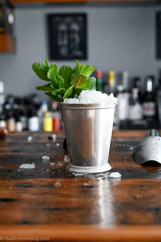 Mint Julep in a silver cup with crushed ice and mint leaves on wooden table