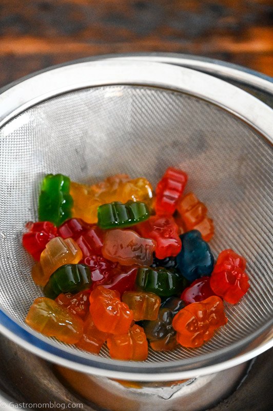 draining colorful gummy bears in a mesh strainer