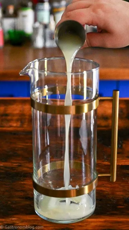 lemon juice being poured into a gold banded pitcher