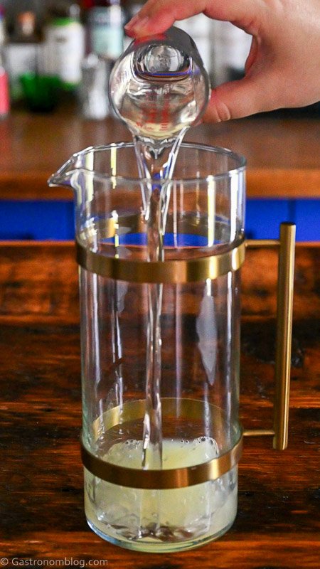 simple syrup being poured into a gold banded pitcher