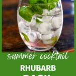 Pink Rhubarb Cocktail in glass with ice balls and basil garnish