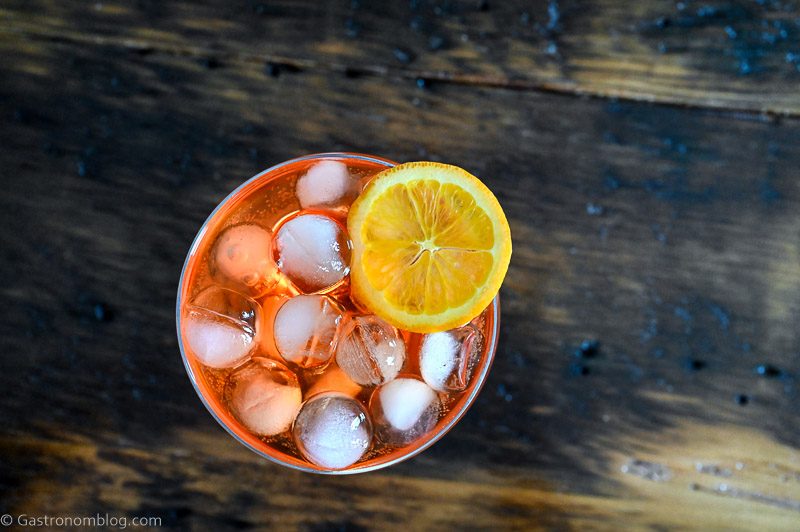 orange Aperol Spritz Aperitivo in glass with ice on wooden table