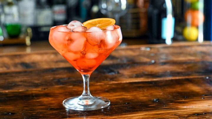 orange Aperol Spritz Aperitivo in glass with ice on wooden table