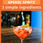 orange Aperol Spritz Aperitivo in glass with ice on wooden table