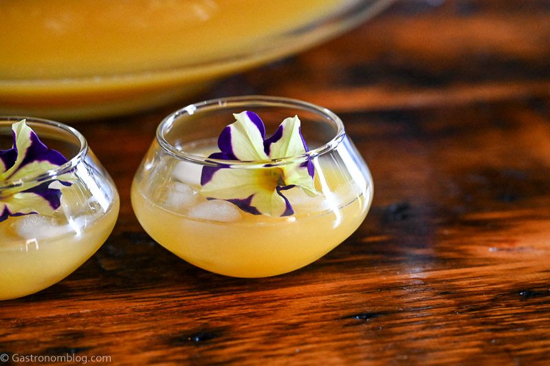 Yellow Pineapple Wine Punch in punch cups with edible flower