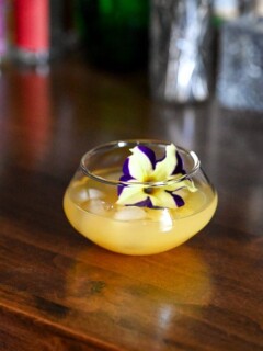 Yellow Pineapple Wine Punch in punch cup with edible flower