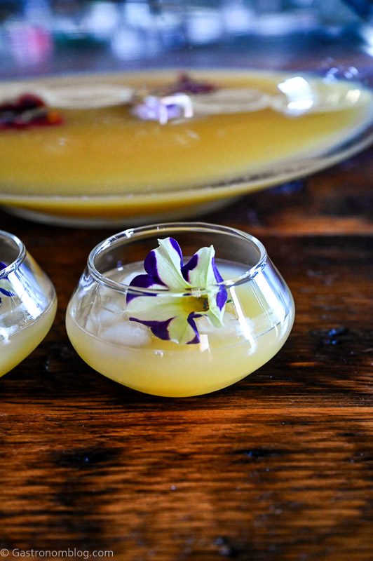 Yellow Pineapple Wine Punch in punch cups with edible flower