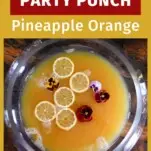 Yellow Pineapple Wine Punch in punch bowl with edible flowers and citrus slices