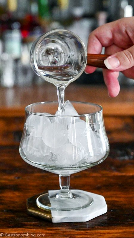 club soda being poured into glass with ice