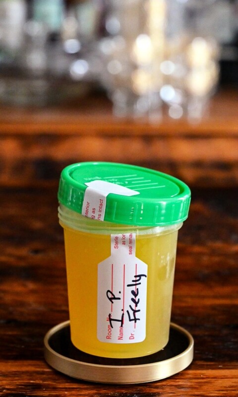 yellow Specimen cocktail in specimen container with green lid