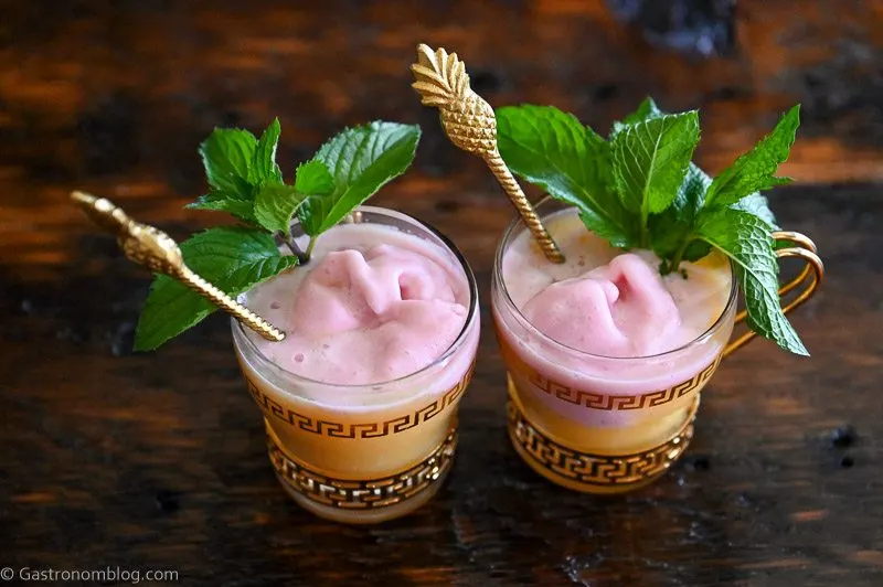 orange pineapple orange punch in gold trimmed punch cups topped with raspberry sherbet and mint leaves