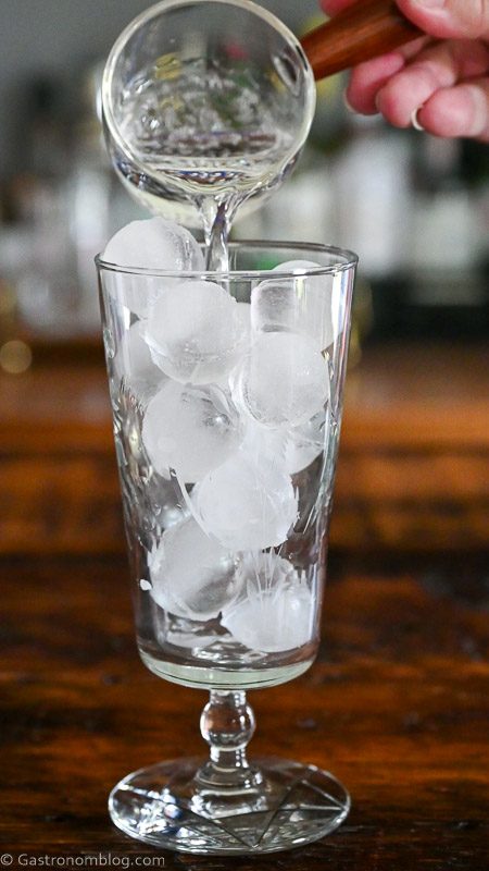 pouring club soda into ice filled glass